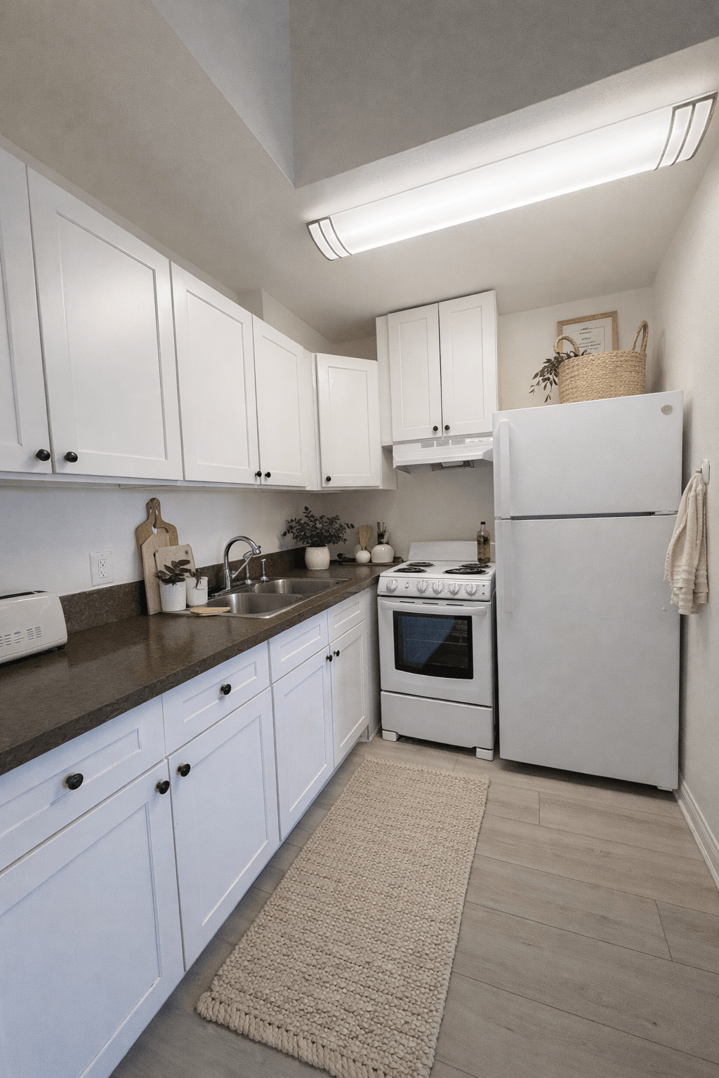 A kitchen with white cabinets and a white refrigerator.